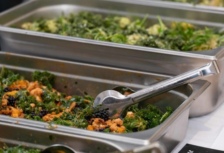 A range of vegetable dishes in large metal trays ready to be served at a conference. The dishes are made up of local, organic, seasonal (Autumn) and surplus vegetables